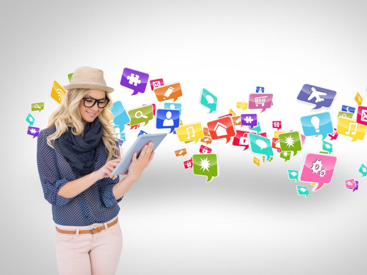 Woman looking at iPad as social media Icons float around her - The biggest trends in graphic design - Image